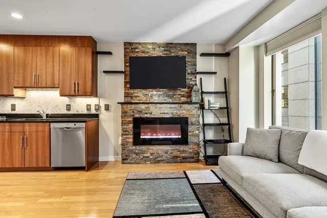 a living room with furniture a flat screen tv and a fireplace