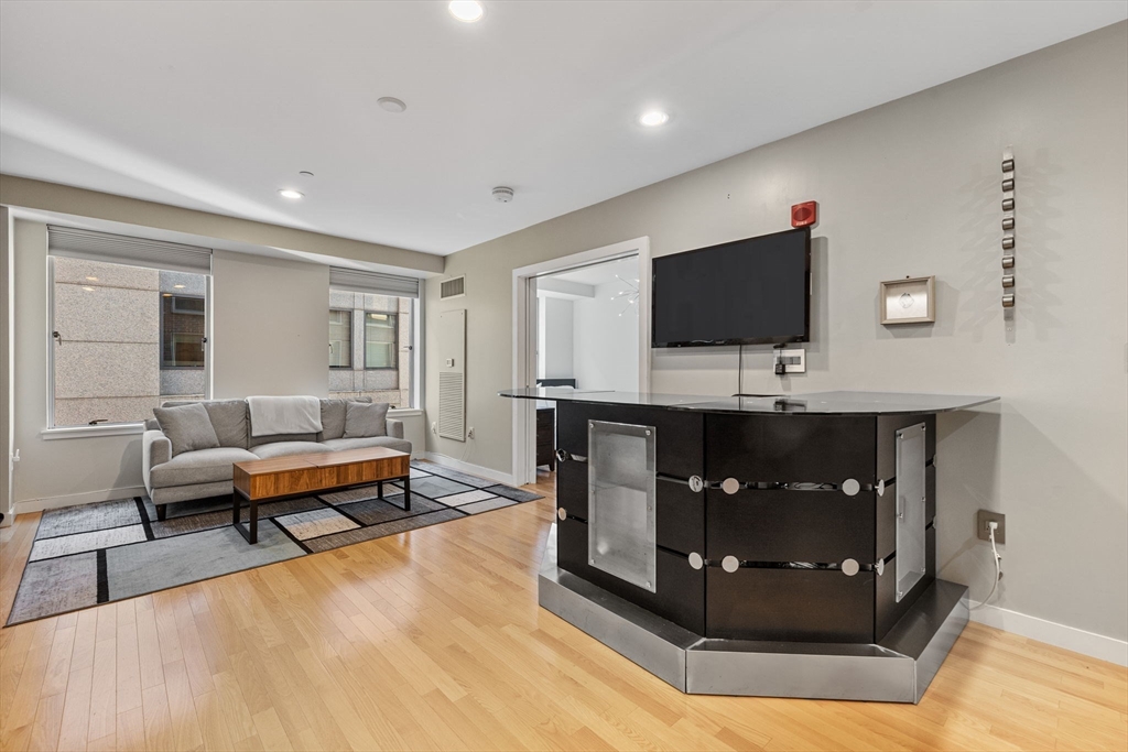 80 Broad Street, Unit 805 Boston, MA 02110 - Photo 6 of 22 a living room with furniture and a flat screen tv