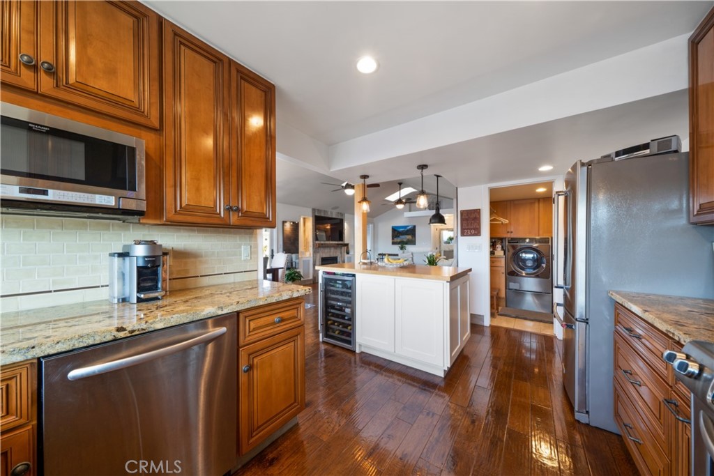 53 Saratoga Newport Beach, CA 92660 - Photo 9 of 31 a kitchen with stainless steel appliances granite countertop a refrigerator a sink dishwasher a stove and white countertops with wooden floor