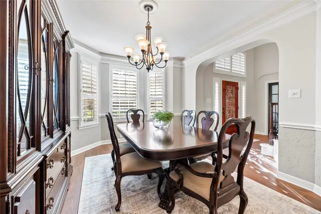 a dining room with furniture a chandelier and wooden floor