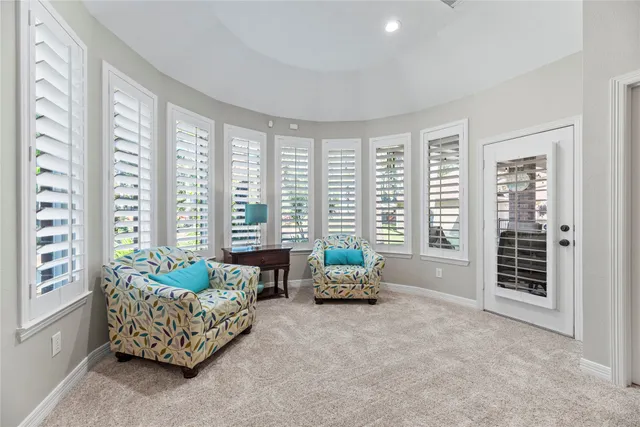a living room with furniture and large windows
