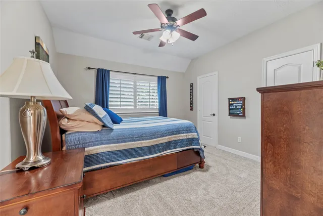 a bedroom with a bed and a ceiling fan