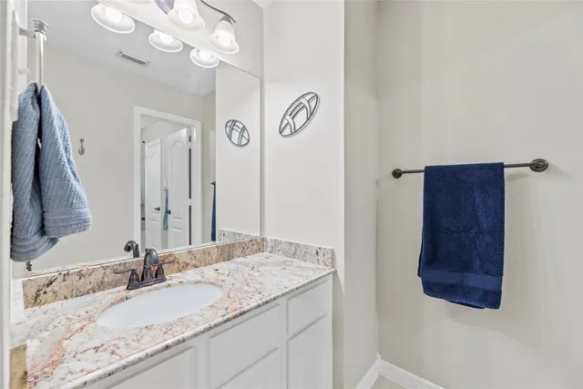 a bathroom with a granite countertop sink and a mirror