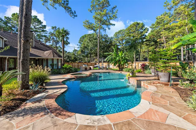 a swimming pool with outdoor seating and plants