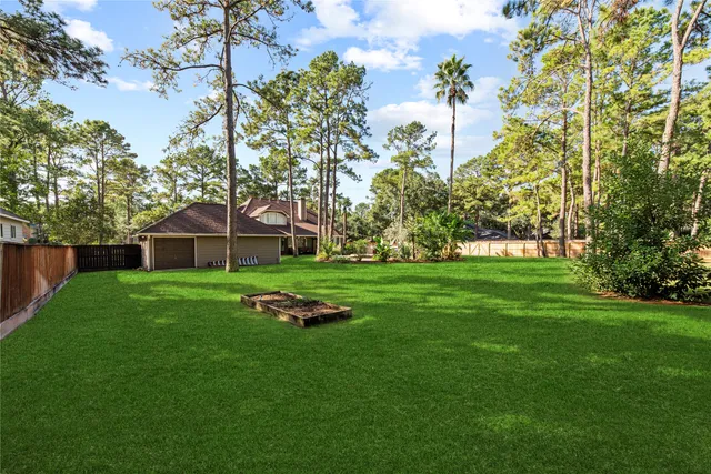 a view of a white house with a big yard and potted plants
