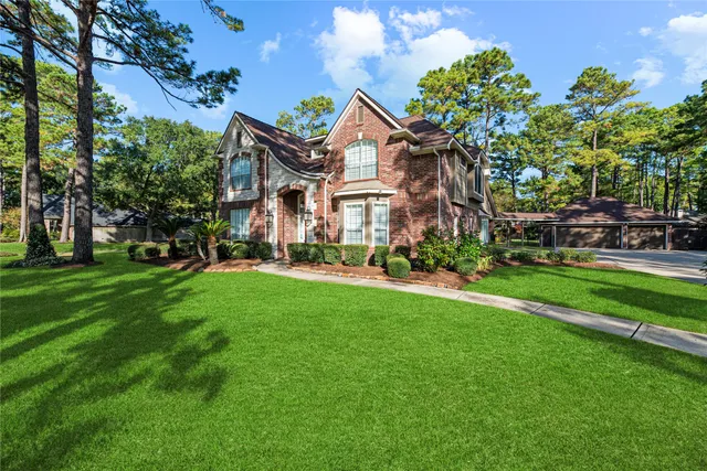 a view of a white house with a big yard and potted plants