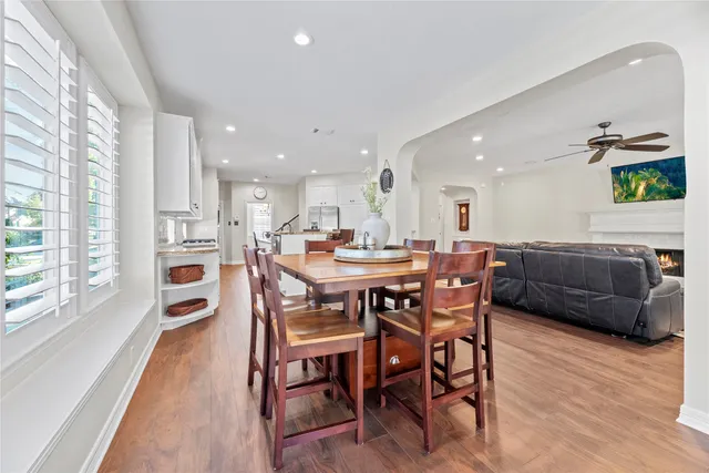a kitchen with a dining table chairs and wooden floor