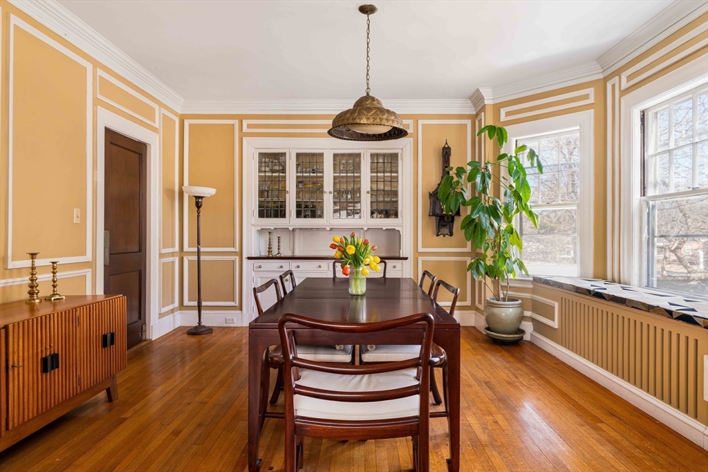 289 Clinton Road Brookline, MA 02445 - Photo 6 of 24 a dining room with furniture a potted plant and wooden floor