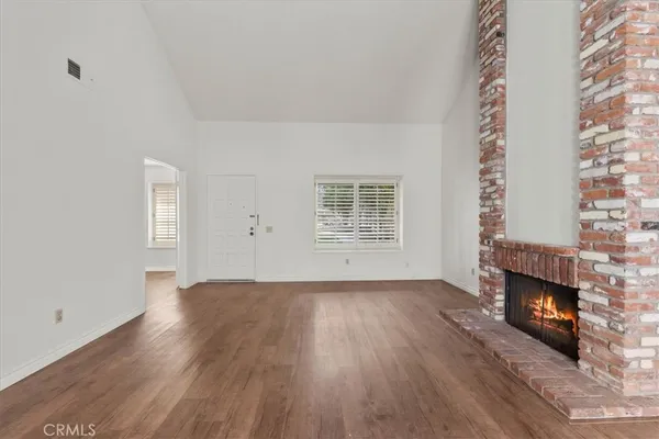 an empty room with windows and fireplace