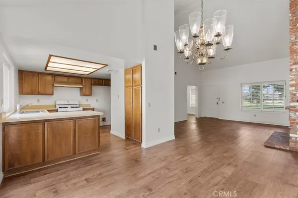 a view of a kitchen with a sink and dishwasher with wooden floor