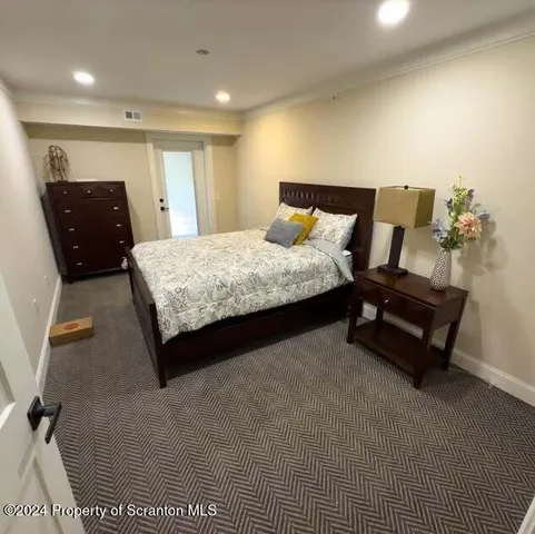a spacious bedroom with a bed and dresser