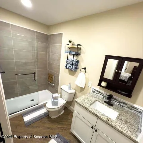 a bathroom with a sink a toilet and shower