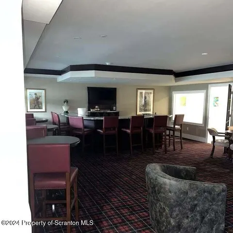 a living room with furniture a large window and a dining table