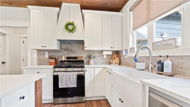 a kitchen with white cabinets and appliances