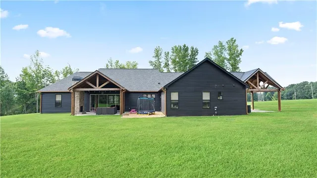 a front view of a house with a yard and trees