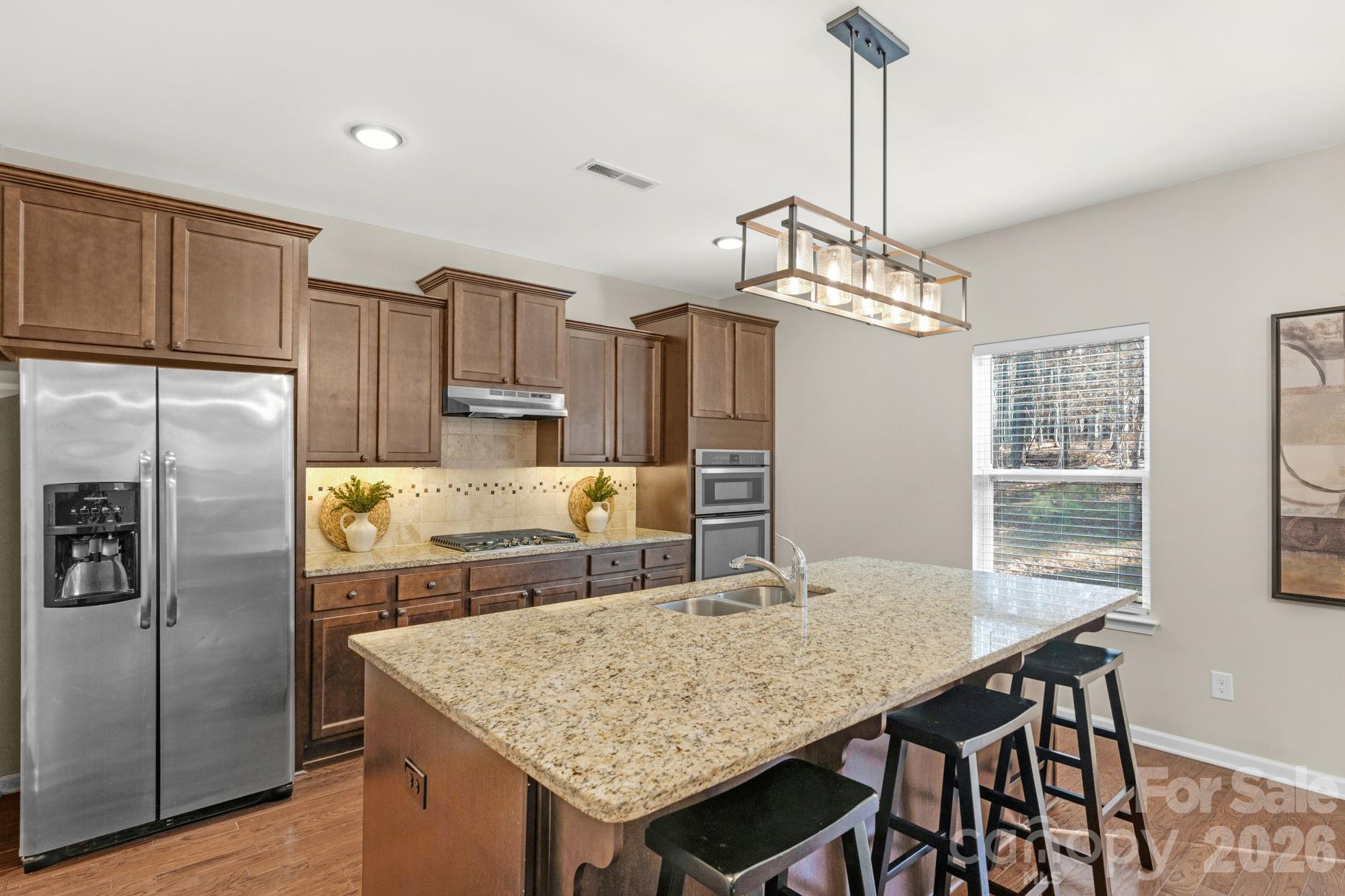 1508 Springfield Drive Waxhaw, NC 28173 - Photo 11 of 48 a kitchen with stainless steel appliances granite countertop a kitchen island a stove a table and chairs