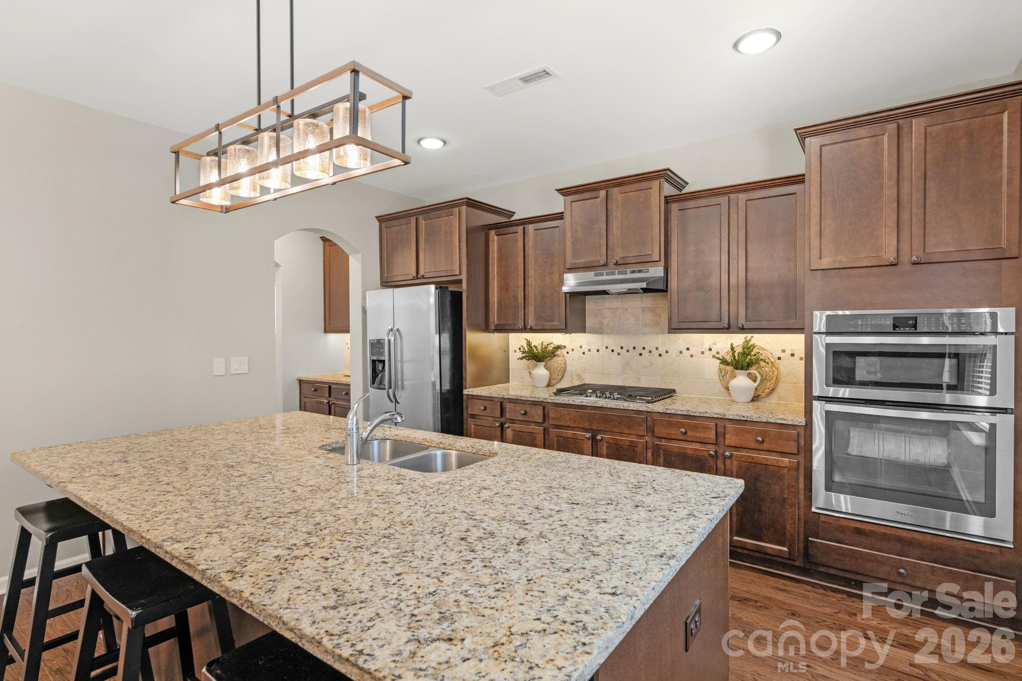 1508 Springfield Drive Waxhaw, NC 28173 - Photo 14 of 48 a kitchen with kitchen island granite countertop a table chairs stove and refrigerator