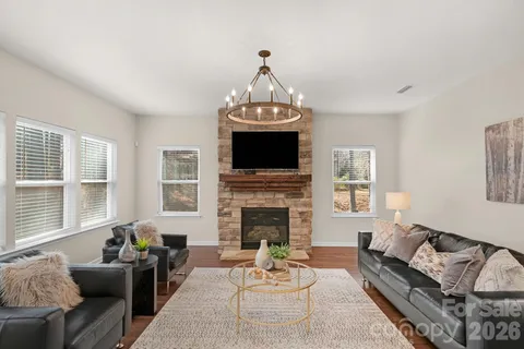 a living room with furniture a fireplace and a chandelier