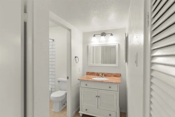 a bathroom with a granite countertop sink toilet and shower