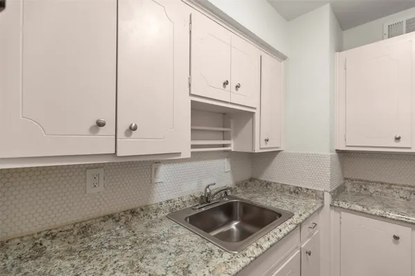 a kitchen with granite countertop a sink and a stove