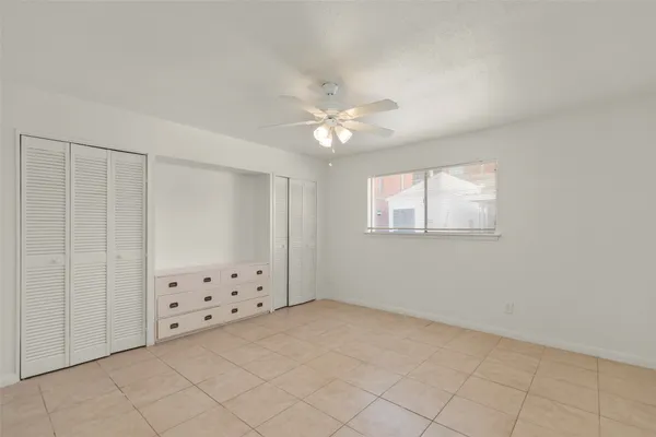 an empty room with chandelier fan