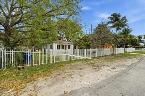 a view of a house with a backyard and a tree