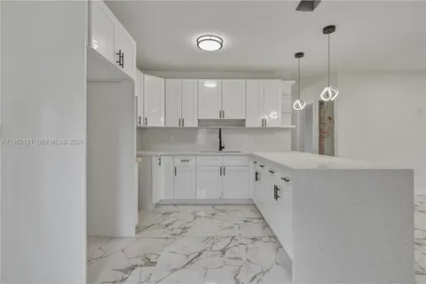 a kitchen with white cabinets and white appliances