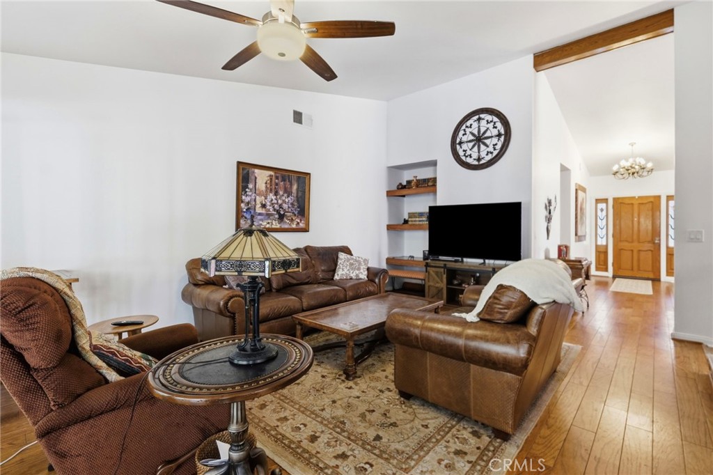 18233 Charlton Lane Porter Ranch, CA 91326 - Photo 32 of 40 a living room with furniture a flat screen tv and a wall painting
