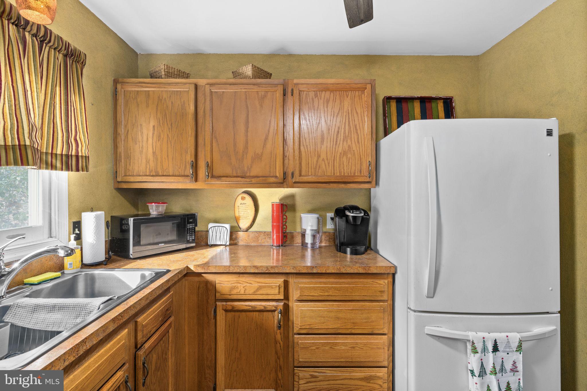 227 Cedar Ridge Drive Ruther Glen, VA 22546 - Photo 13 of 44 a kitchen with refrigerator and cabinets