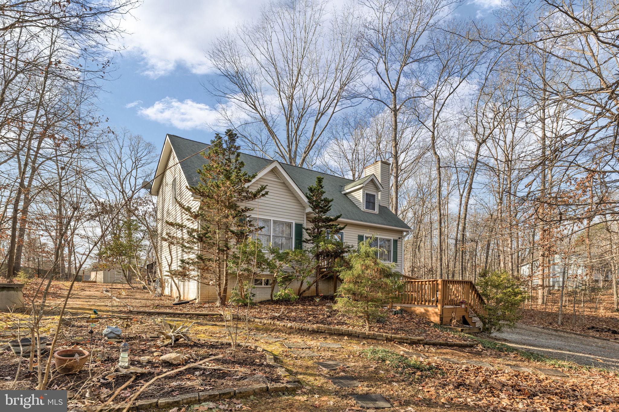 227 Cedar Ridge Drive Ruther Glen, VA 22546 - Photo 3 of 44 a view of a large white house with a big yard and large trees
