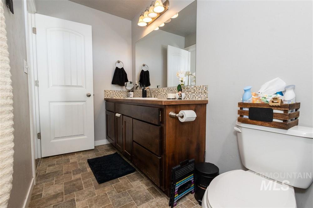2160 East Ridgeview Avenue Payette, ID 83661 - Photo 15 of 32 Wood-finish vanity with an integrated sink and mosaic tile backsplash