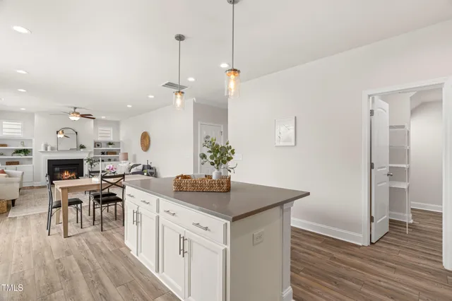 a kitchen with stainless steel appliances a kitchen island hardwood floor and a sink