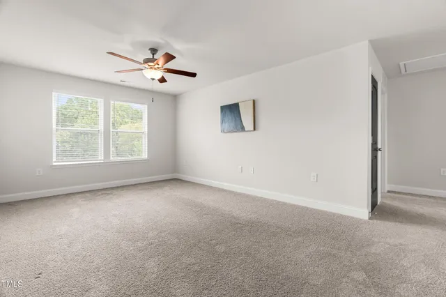 an empty room with fan and windows