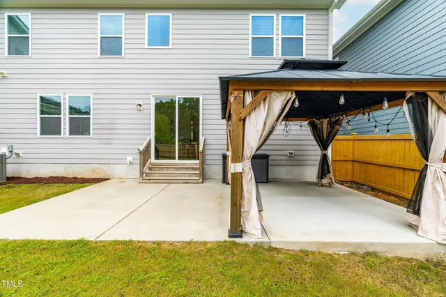 a view of a patio with table and chairs with wooden floor and fence