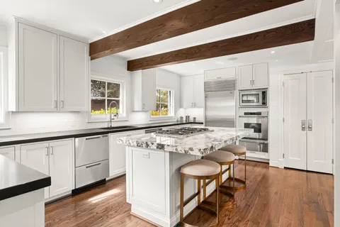 a dining room with furniture a chandelier and wooden floor