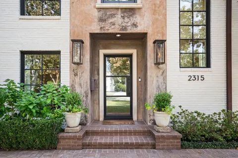 a front view of a house with a yard and tree s