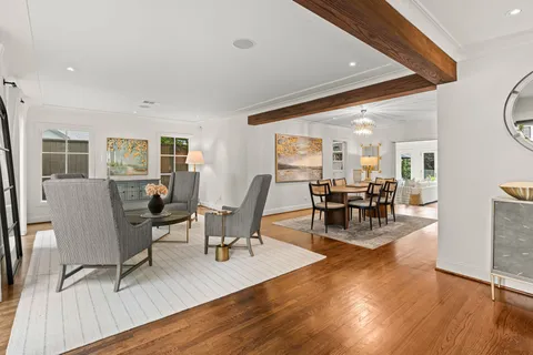 a living room with furniture a wooden floor and next to a window