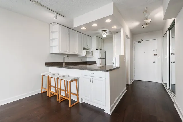 a kitchen with stainless steel appliances granite countertop a refrigerator and a stove top oven