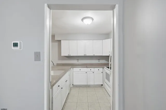 a kitchen with white cabinets and white appliances