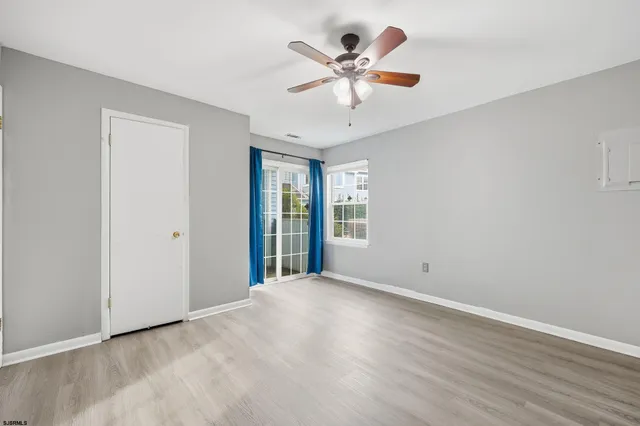 a view of a room with wooden floor and a ceiling fan