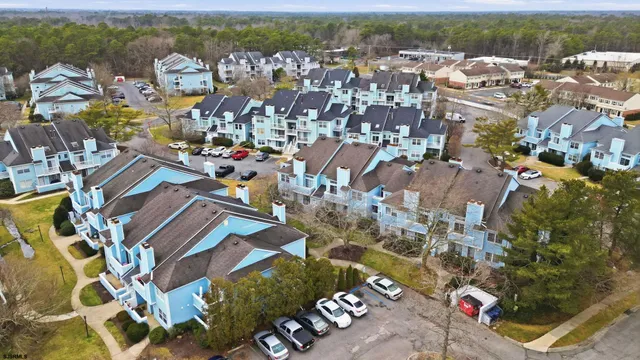an aerial view of a house with swimming pool and large trees