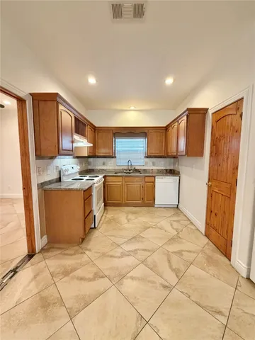 a kitchen with a refrigerator and a stove top oven