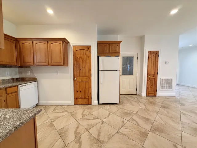 a view of a livingroom with a ceiling fan & kitchen space