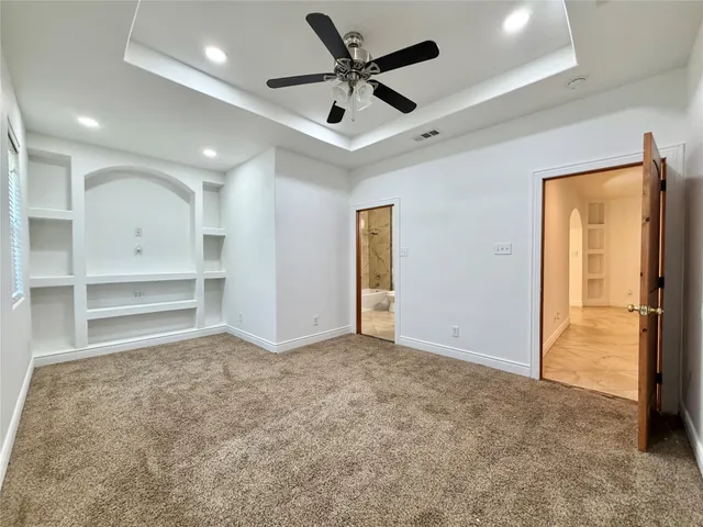 en empty room with windows and ceiling fan