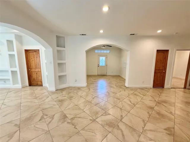 a view of a livingroom with wooden floor and kitchen space