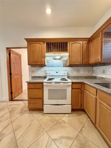 a large kitchen with stainless steel appliances granite countertop a stove a sink a microwave and a refrigerator