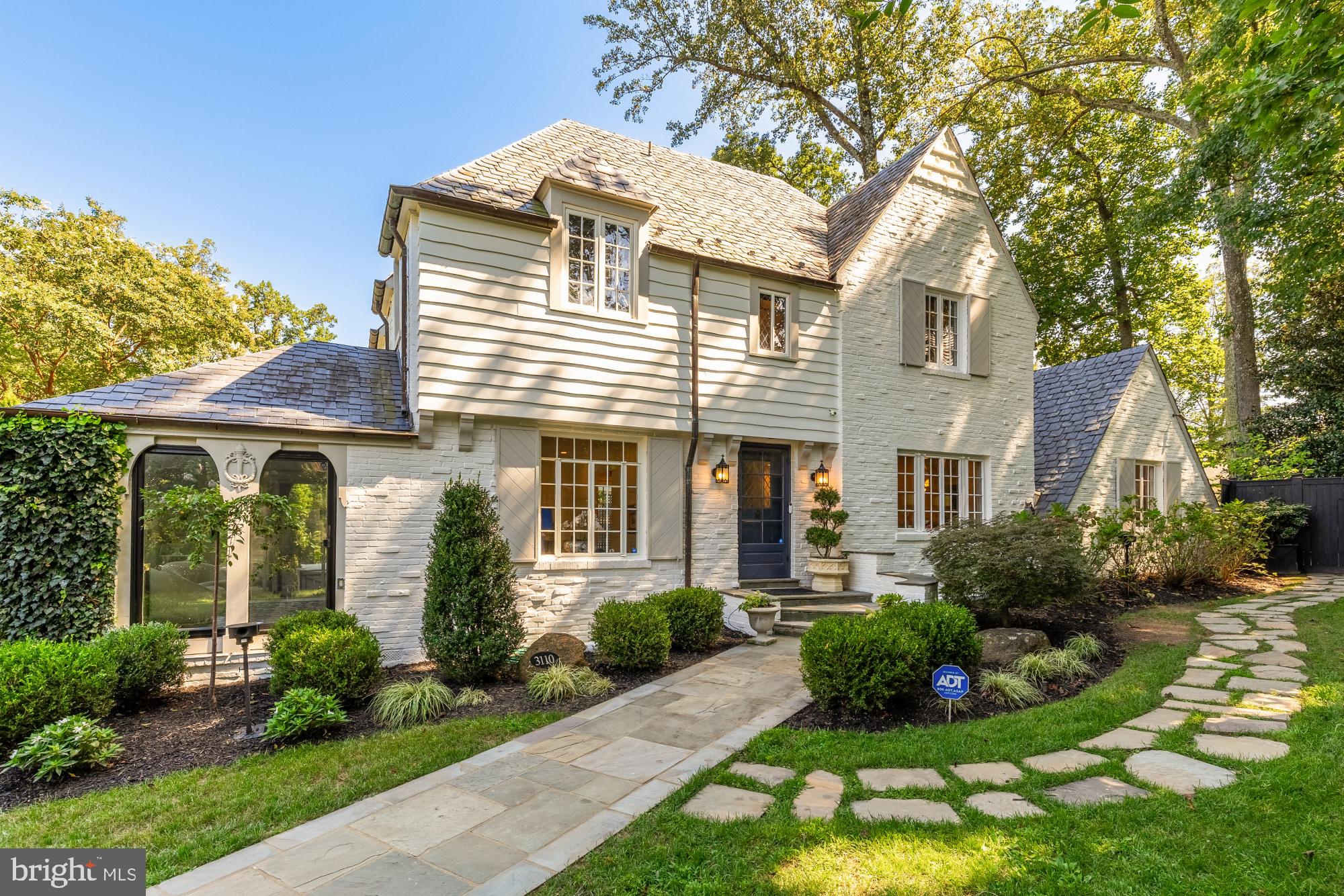 3110 Rolling Road Chevy Chase, MD 20815 - Photo 1 of 64 a front view of a house with a yard and potted plants