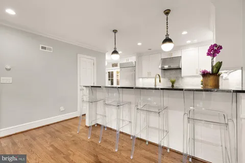 a kitchen with granite countertop a stove and a wooden floors