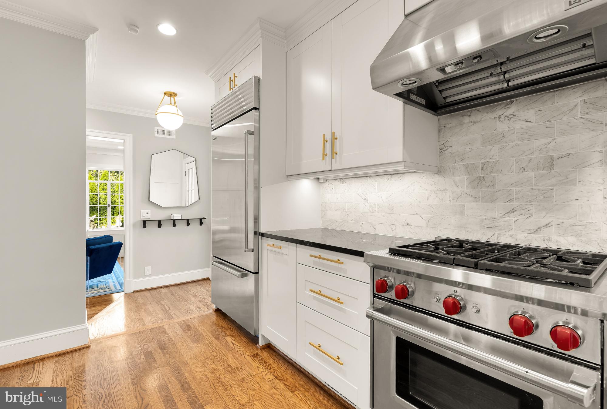 3110 Rolling Road Chevy Chase, MD 20815 - Photo 20 of 64 a kitchen with granite countertop a stove and a wooden floors