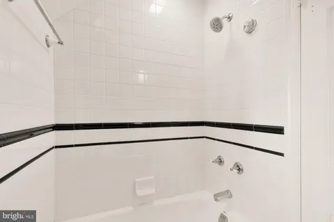 a bathroom with a granite countertop sink a mirror and shower